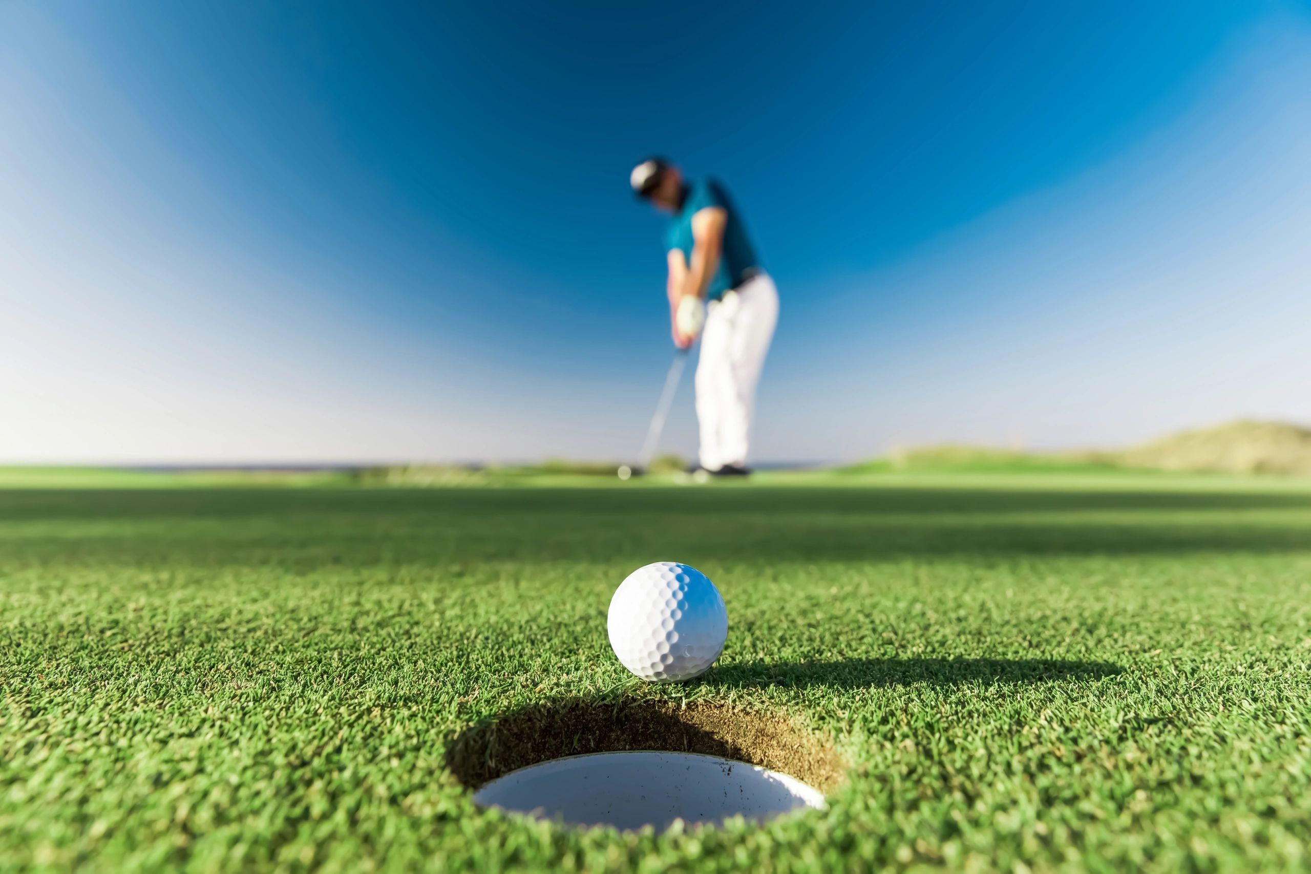 Golf instructor demonstrating a swing to a student